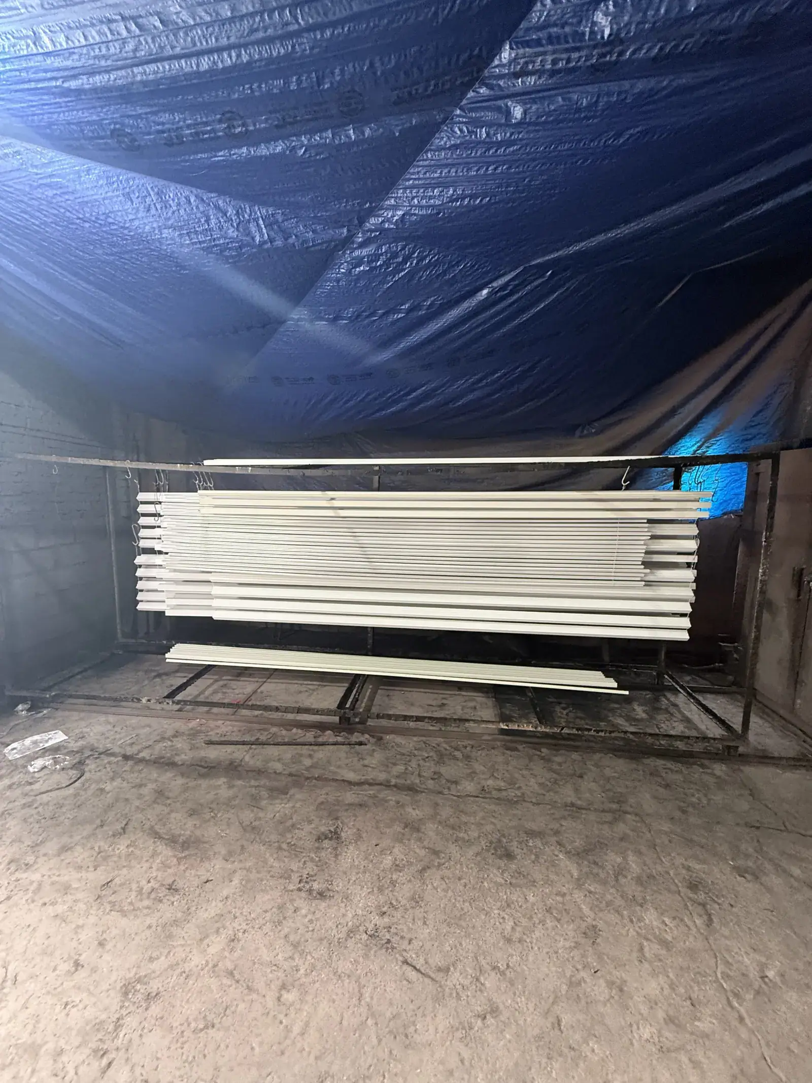 White powder coated aluminium profiles hanging to cure in Raipur